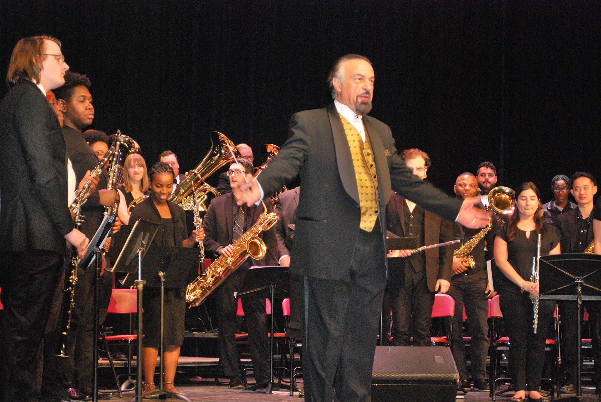 Music instructor and students face the audience after musical performance