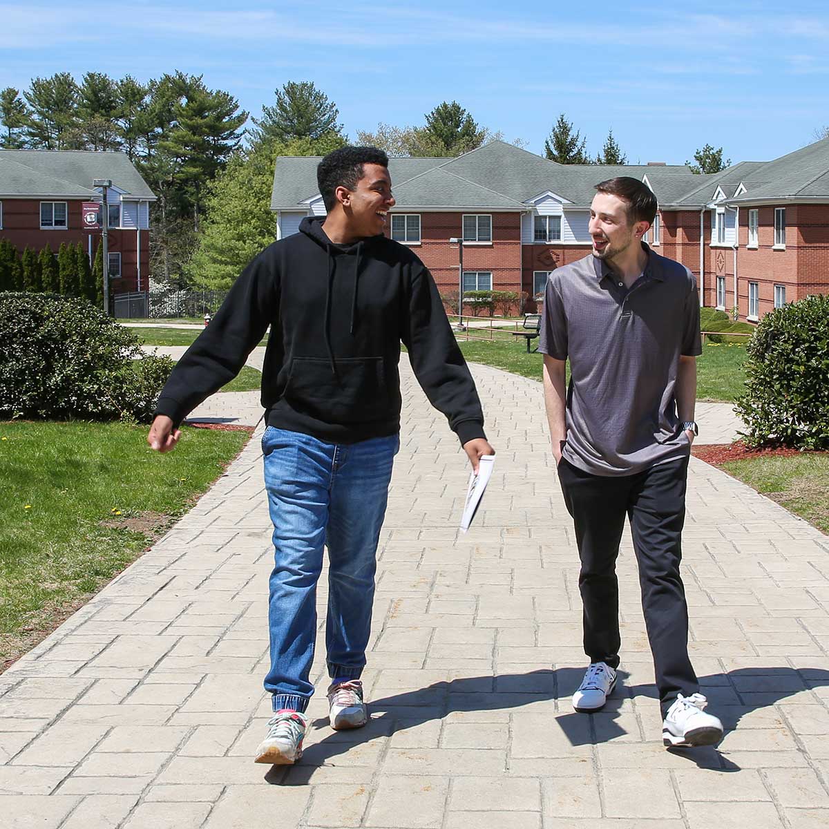Two young men walk on campus, talking about creative opportunities—their college is the only launchpad they need.